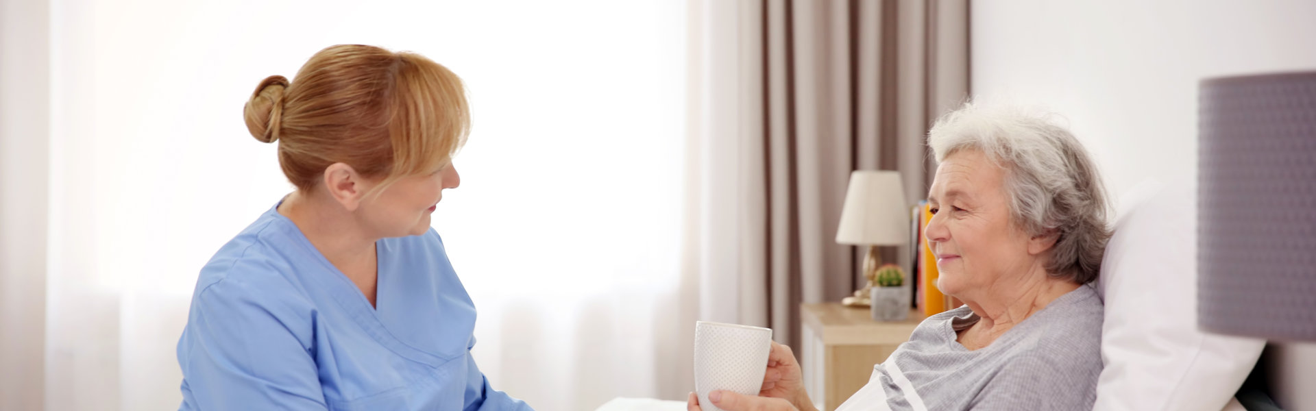 caregiver with senior woman in bed
