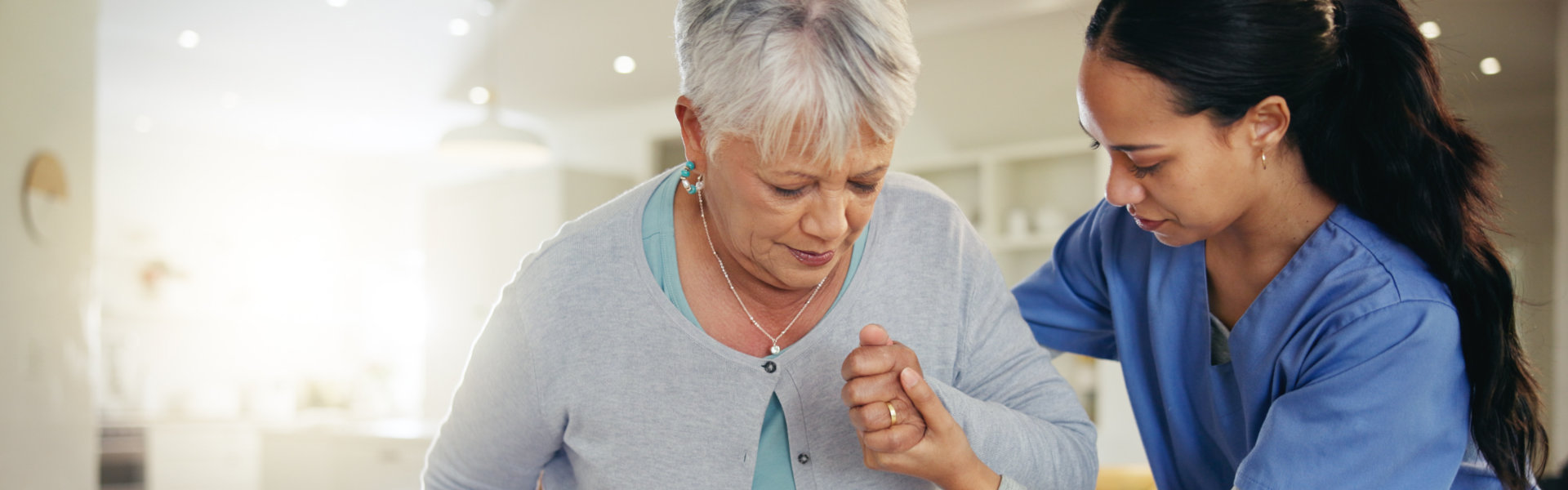 nurse helping a senior to sit