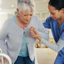 nurse helping a senior to sit