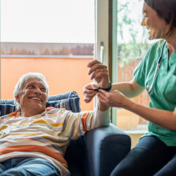 Home caregiver examining elder man