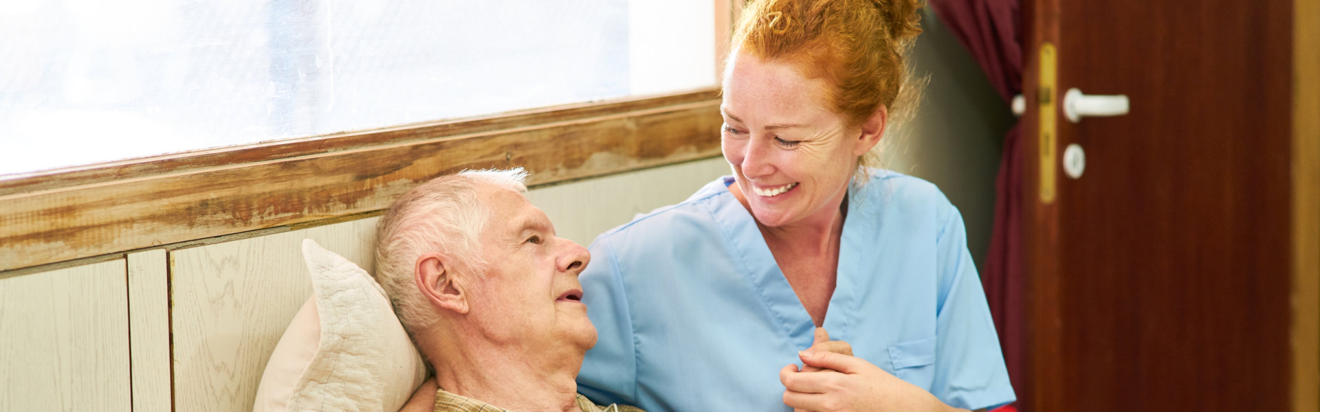 senior man in bed with caregiver
