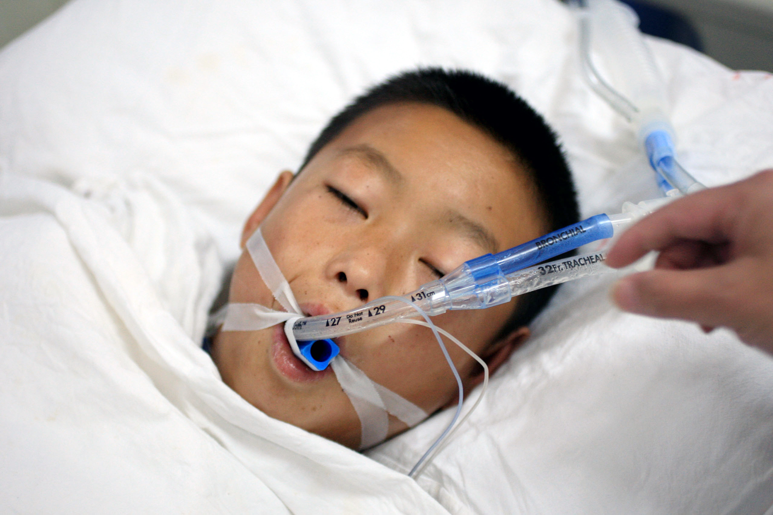 Young doctor hugging little girl in hospital room